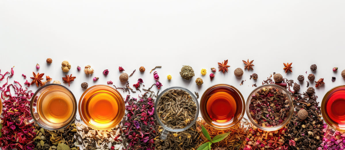 Loose leaf tea blends in glass cups surrounded by dried flowers, spices and tea leaves, by Bettina's Tea